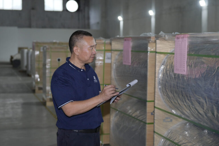 Staff member checking wrapped material rolls