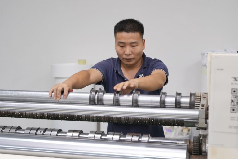 Operator adjusting rollers on converting equipment