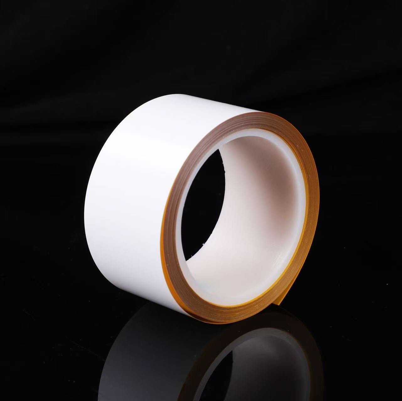 White polyimide label roll photographed on a black background